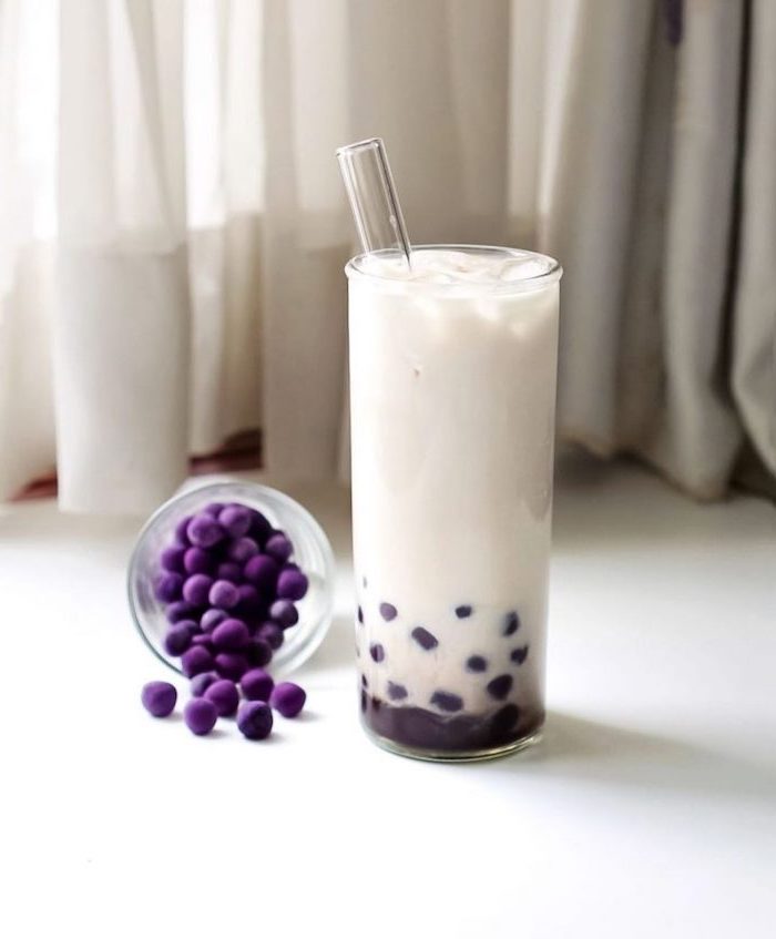 purple boba tapioca pearls what is boba made of glass of white milk with glass straw placed on white surface