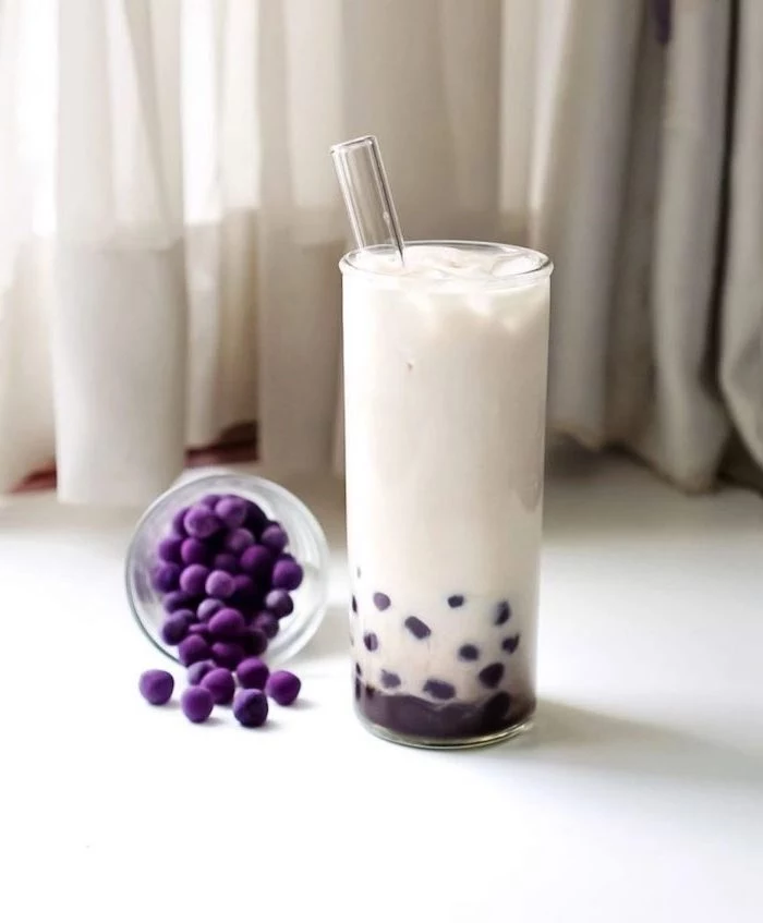 purple boba tapioca pearls what is boba made of glass of white milk with glass straw placed on white surface
