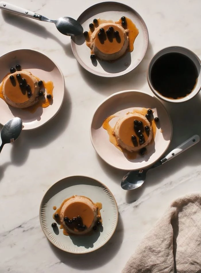 recipe for flan with tapioca pearls what is boba tea flans placed on white ceramic plates arranged on marble surface spoons next to them