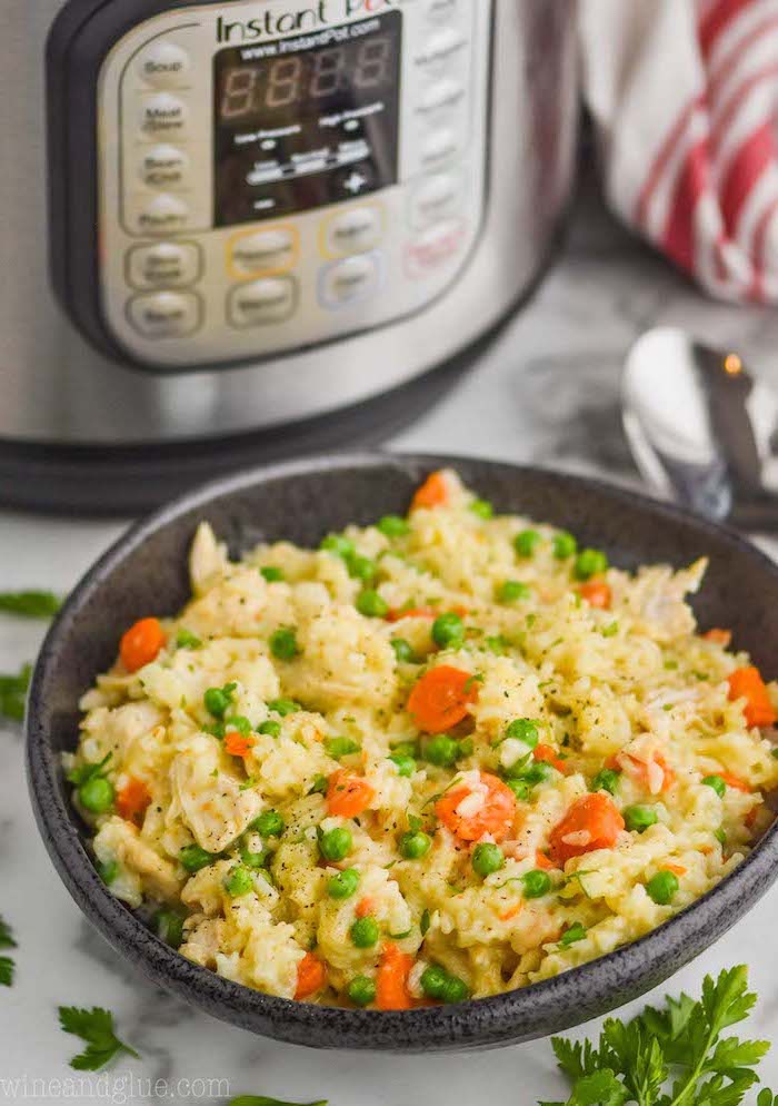 stir fry chicken rice with carrots peas inside black ceramic bowl healthy instant pot recipes placed on white surface next to instant pot