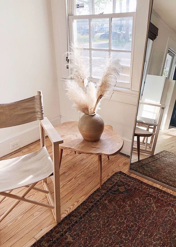 tall mirror where to buy pampas grass wooden chair and side table next to it ceramic vase with pampas grass