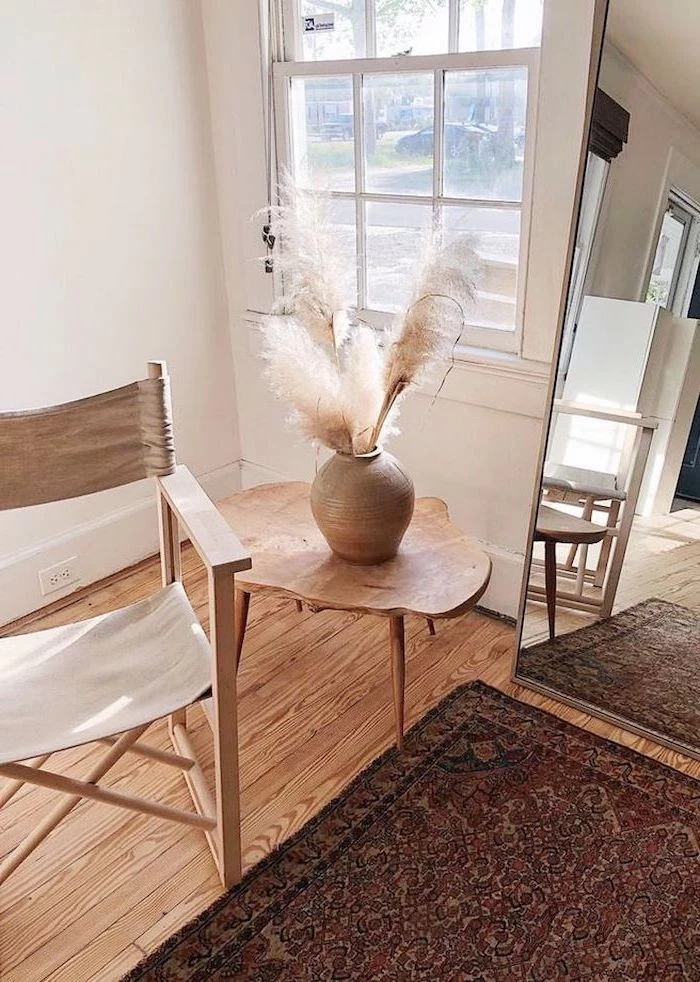 tall mirror where to buy pampas grass wooden chair and side table next to it ceramic vase with pampas grass