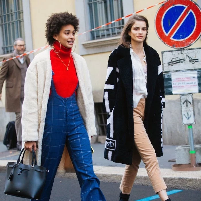 two women walking down the street wearing different outfits pinterest cute outfits blue onesie with red polo sweater beige trousers with white shirt black coat