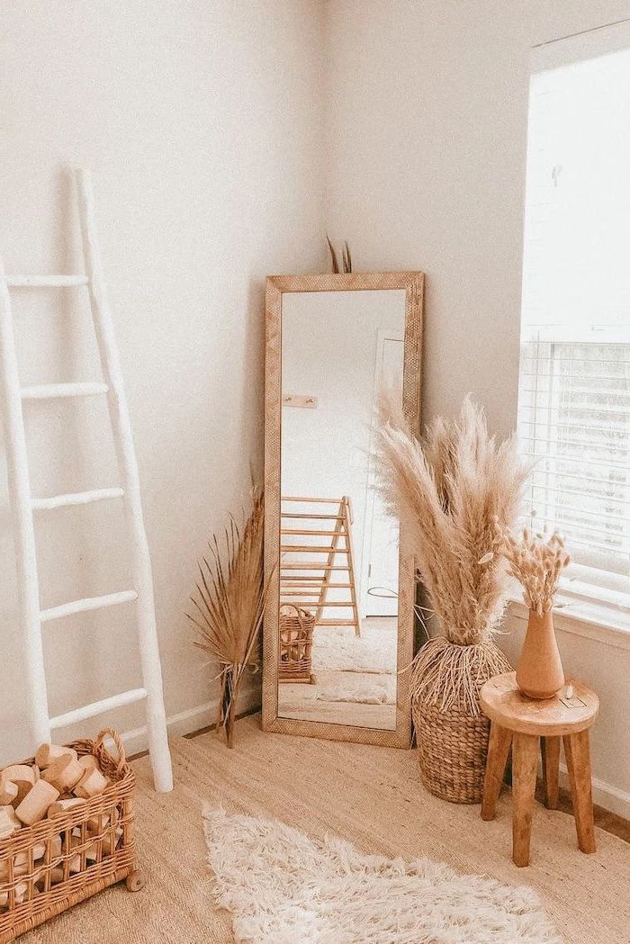 wooden floor white walls tall mirror surrounded by wooden vases and chair where to buy pampas grass