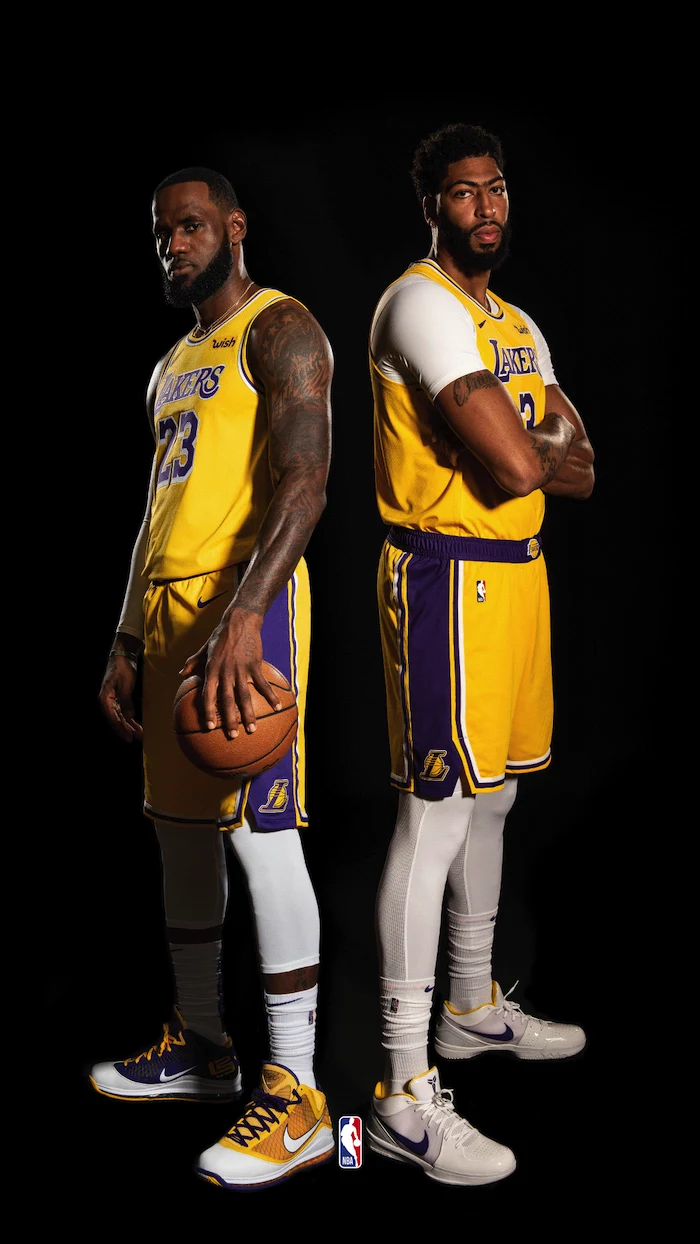anthony davis and lebron james wearing gold lakers uniforms nba wallpaper iphone standing next to each other on black background