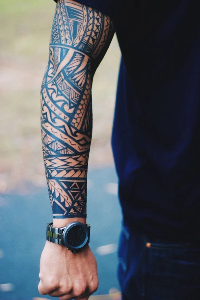 arm sleeve maori tattoo with black ink on man wearing watch jeans black t shirt back tattoos for men