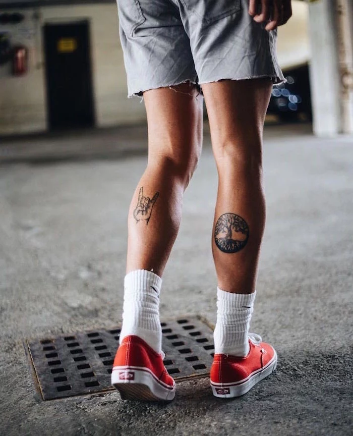 back of legs tattoos on man wearing gray shorts white socks red sneakers shoulder tattoos for men tree of life rock on symbols