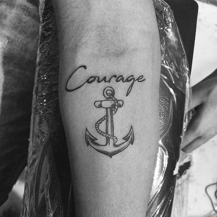 back tattoos for men courage written in cursive above anchor with rope forearm tattoo black and white photo