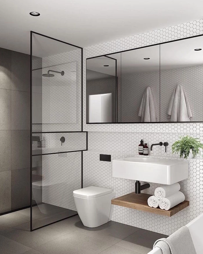 bathroom design with white honeycomb tiles floating vanity with large mirror above it scandinavian design shower separated with glass