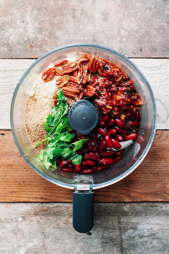 beans pecans breadcrumbs parsley inside a blender placed on wooden surface vegan party appetizers