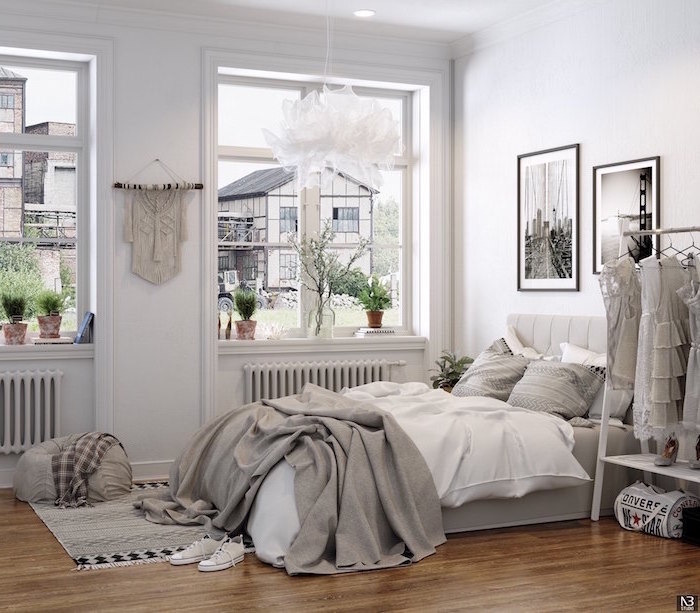 bedroom design with white walls clothing rack black and white photos hanging on the wall above the bed scandinavian design wooden floor