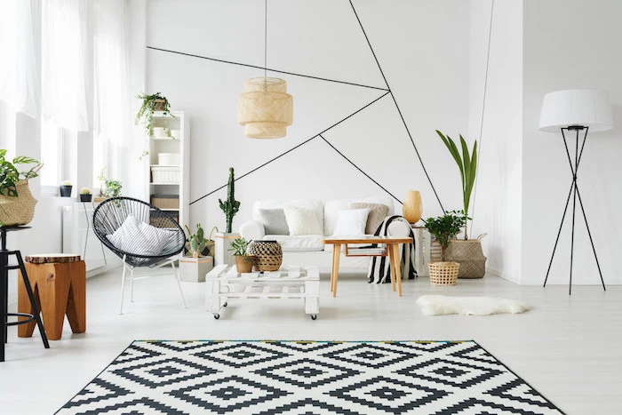 black and white geometrical carpet scandinavian minimalism white sofa black armchair wooden coffee table white walls