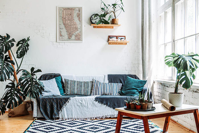 black and white rug on wooden floor scandinavian living room sofa covered with blanket in front of white brick wall