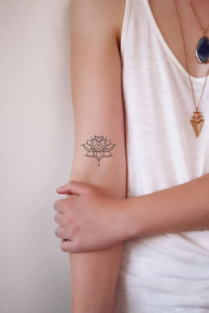 black and white small lotus forearm tattoo tattoo ideas with meanings on woman wearing white top