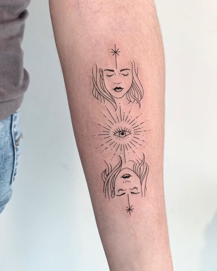 black and white tattoo of all seeing eye with two female faces foorearm tattoo white background