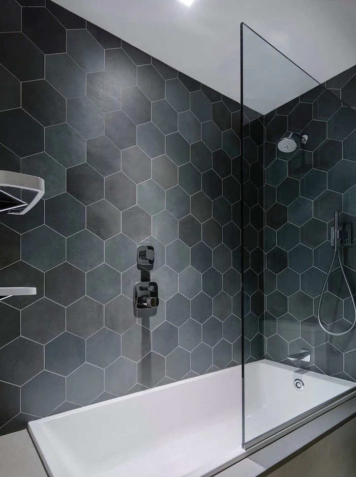 black honeycomb tiles in different shades on the shower walls separated with a glass bathroom wall tile ideas