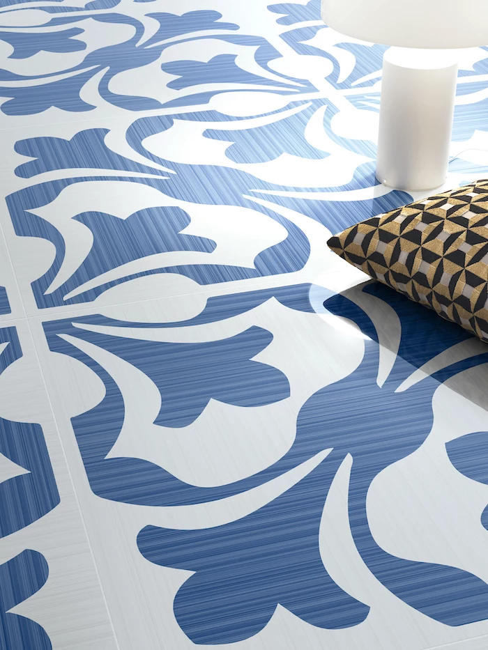 blue and white printed tiles on a floor floor tiles candle and gold and black throw pillow on the floor