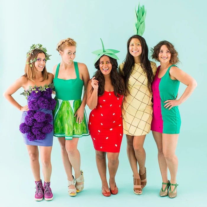 blue background girl group halloween costumes five women dressed as different fruits lime strawberry pineapple