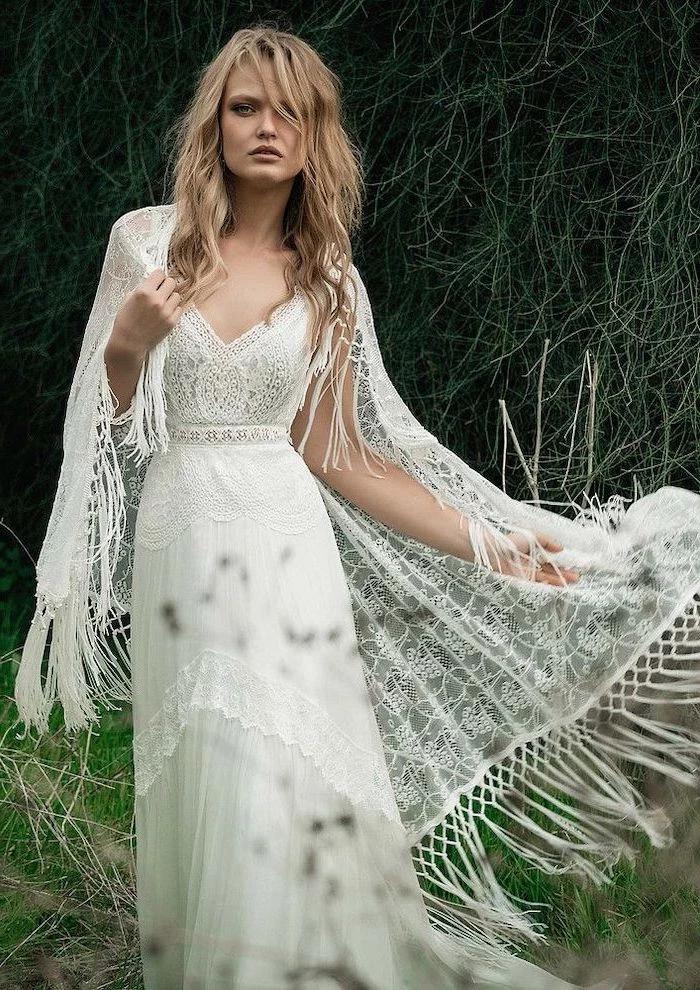 bohemian wedding dress blonde woman with shoulder length wavy hair wearing lace white dress with large white lace scarf