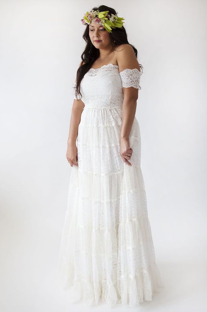 brunette woman with long wavy hair wearing flower crown boho lace wedding dress made of lace with short sleeves