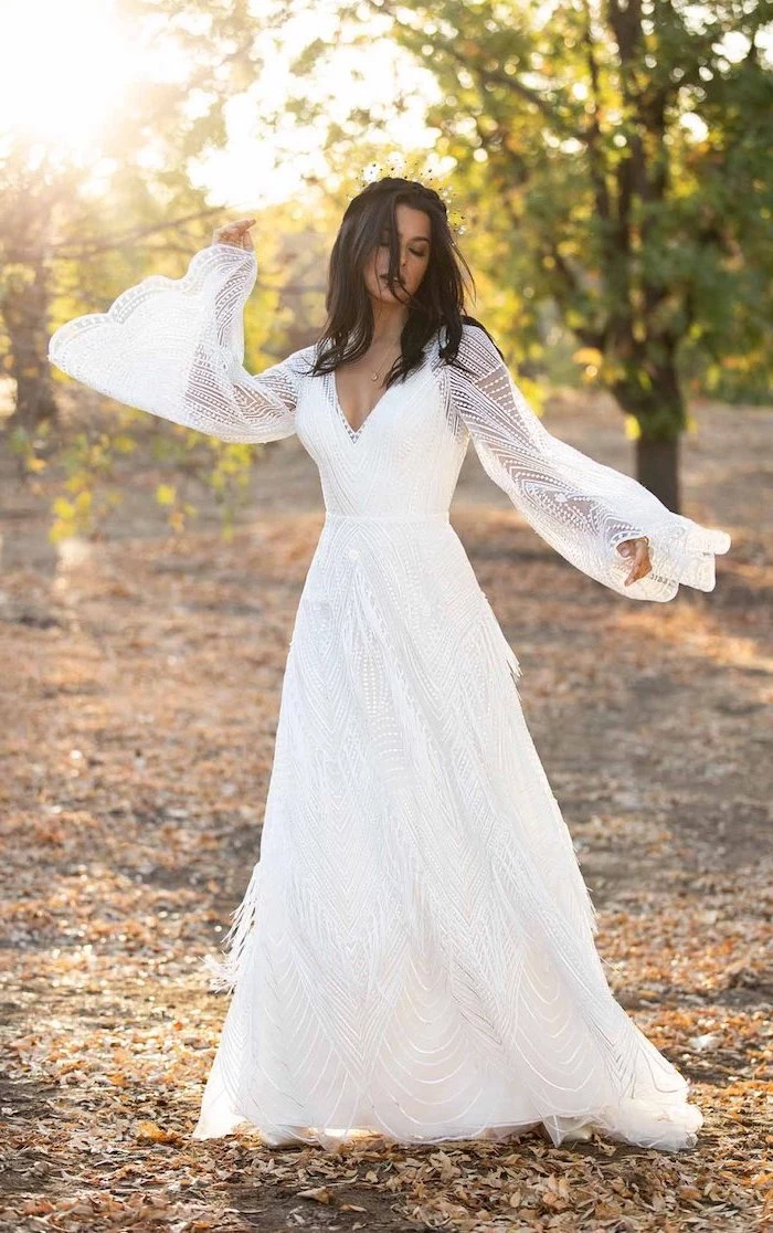 brunette woman with wavy shoulder length hair wearing all lace white unique wedding dresses with bell sleeves