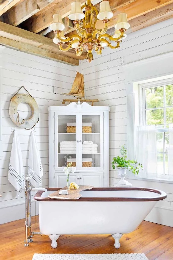 cabinet with towels in the corner vintage bath on wooden floor white shiplap on the walls exposed wood beams on the ceiling bathroom decor signs