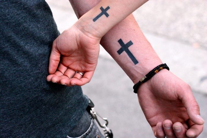 couples matching tattoos tattoos that represent growth two small black crosses on the wrists of man and woman