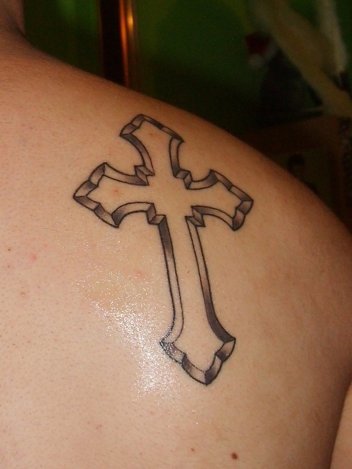 cross silhouette tattooed on shoulder in black and white meaningful tattoo ideas for women