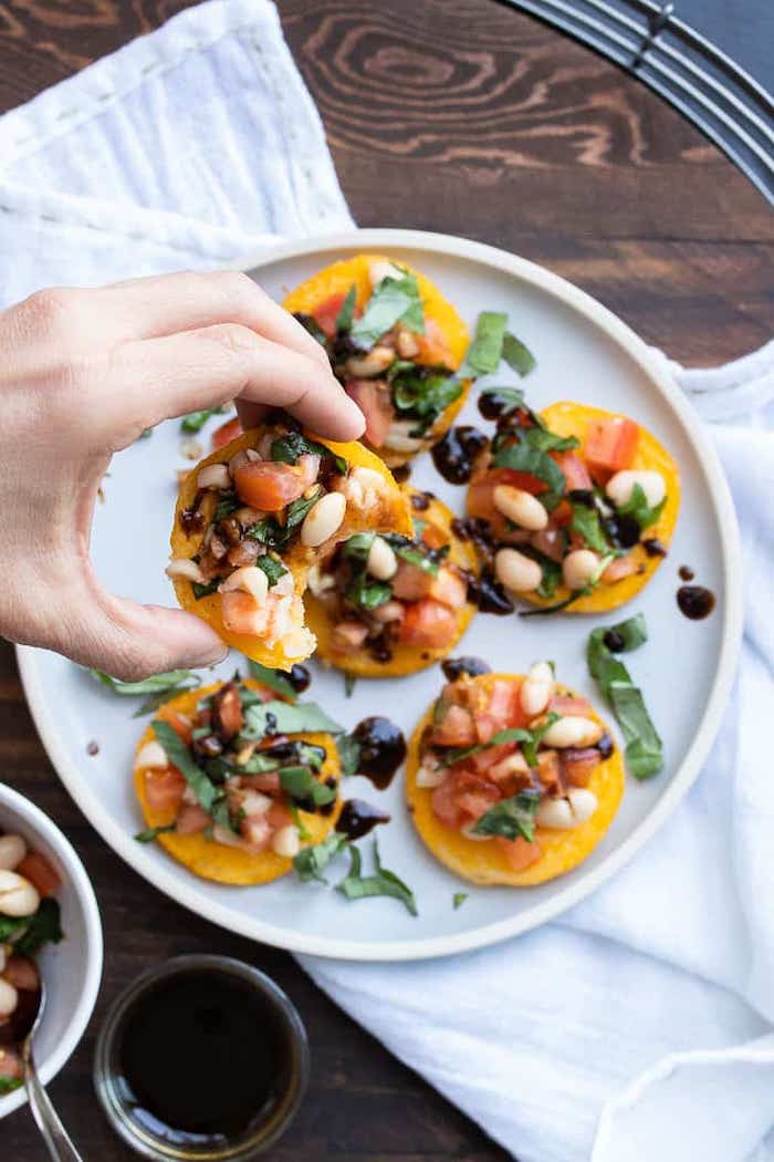 easy vegan appetizers bruschetta with beans chopped tomatoes and parsley arranged in white plate placed on wooden surface