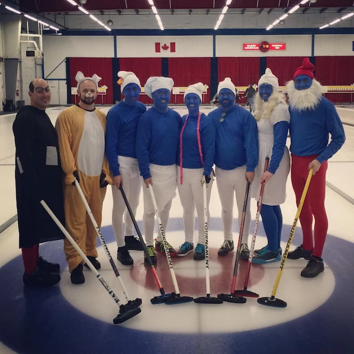 eight people dressed as characters from the smurfs standing on ice hockey ring halloween costume ideas for girls holding sticks