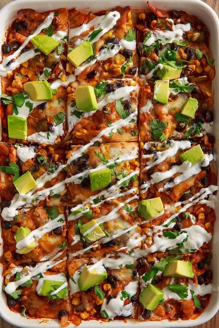 enchilada casserole with black beans corn mexican dishes white sauce on top chopped avocado