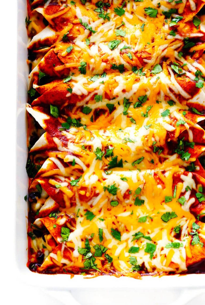 enchiladas with different kinds of cheese fresh parsley authentic mexican food baked in white casserole dish