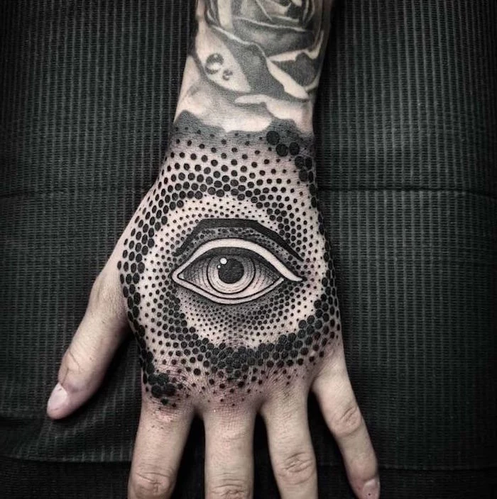 evil eye hand tattoo surrounded by dots in circular shape back tattoos for men black background