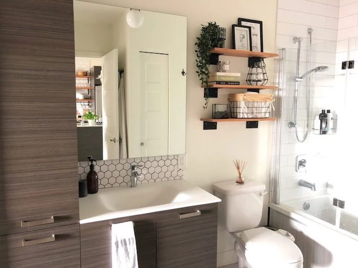 farmhouse bathroom tile dark wooden cabinets white sink mirror above it white subway tiles under the shower