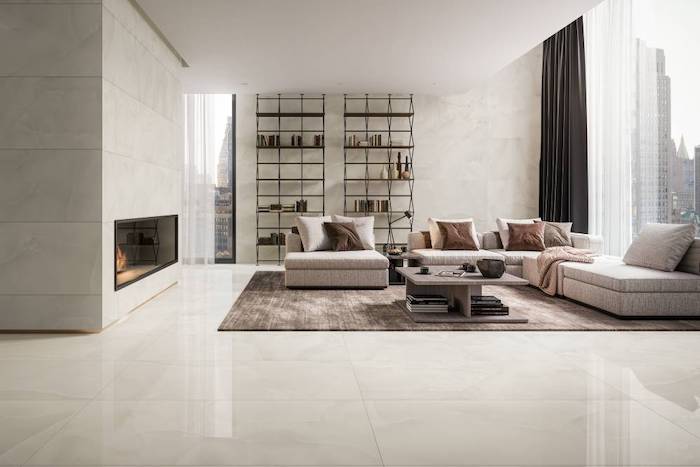 floor tiles all white tiles on the walls and floor large windows white corner sofa two bookshelves wooden coffee table