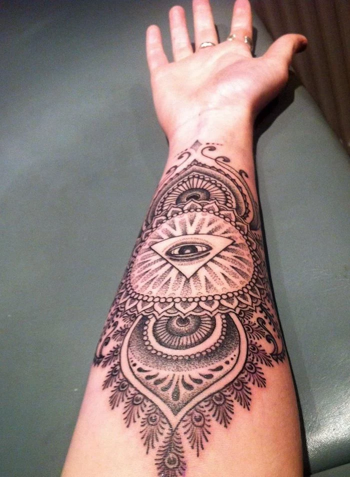 forearm tattoo with all seeing eye in the middle tattoo ideas with meanings mandala shapes around it