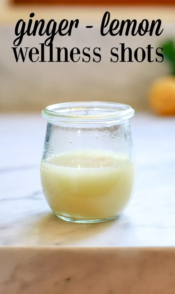 ginger lemon wellness shot inside small glass best cleanse for weight loss placed on marble surface