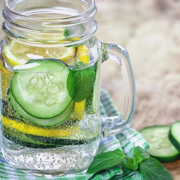 glass filled with soda with cucumber and lemon slices fresh mint leaves best detox drink