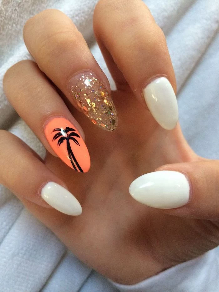 gold leaves decorations on middle finger orange flower with black palm on ring finger short acrylic nails white nail polish on almond shaped nails