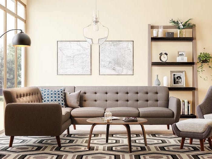 gray corner sofa and armchair wooden round coffee table mid century modern living room white black and brown geometric carpet