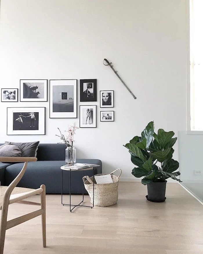 gray sofa framed black and white photos above it scandinavian decor wooden chair wooden floor small side table