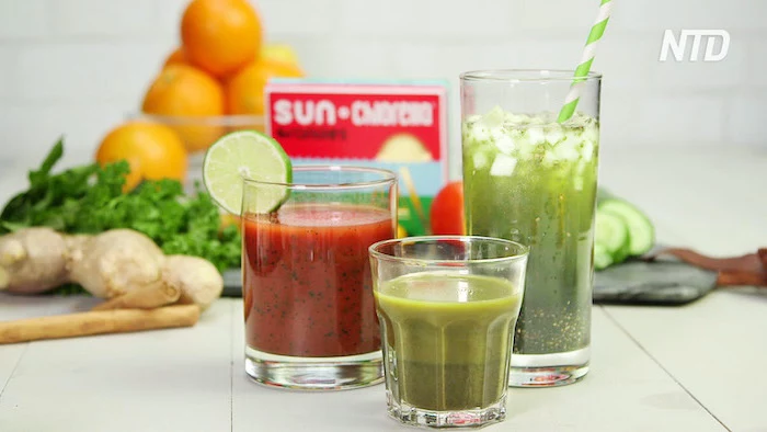 green and red smoothies in three glasses placed on white surface best detox cleanse fruits and vegetables in the background
