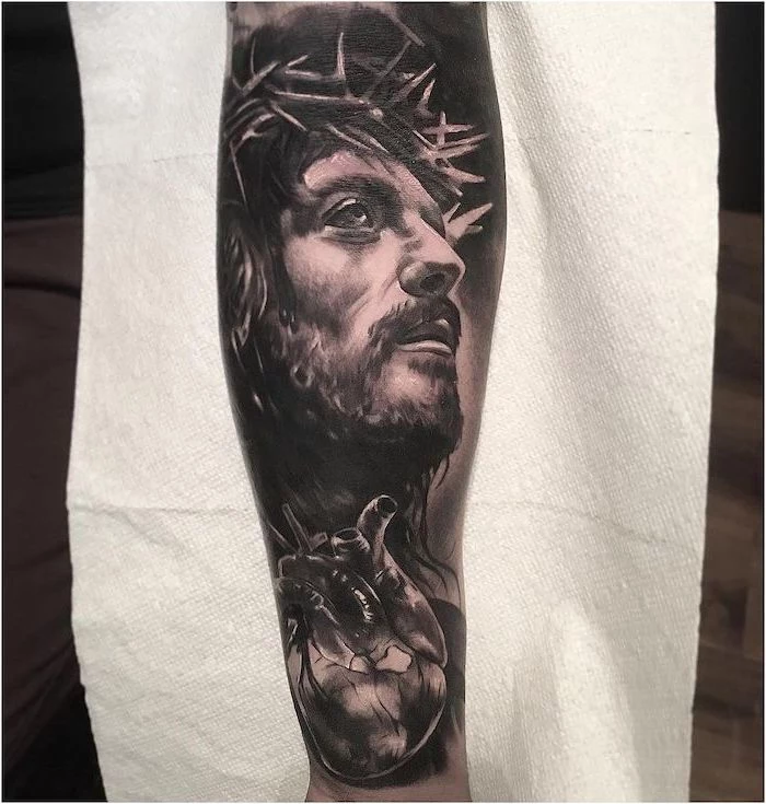 half sleeve tattoo of jesus looking up anatomical heart underneath tattoo ideas with meanings white paper in the background