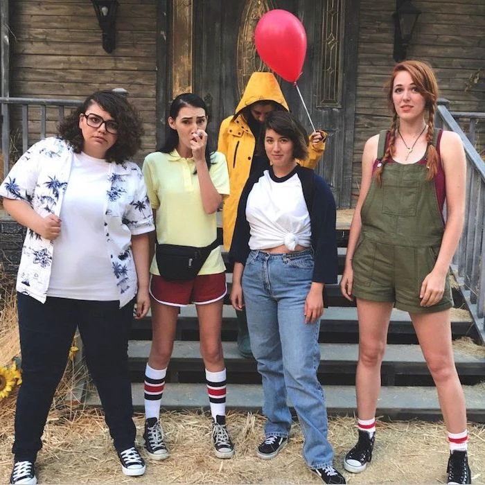 halloween costumes for 3 people five girls dressed as the characters from it standing in front of spooky house