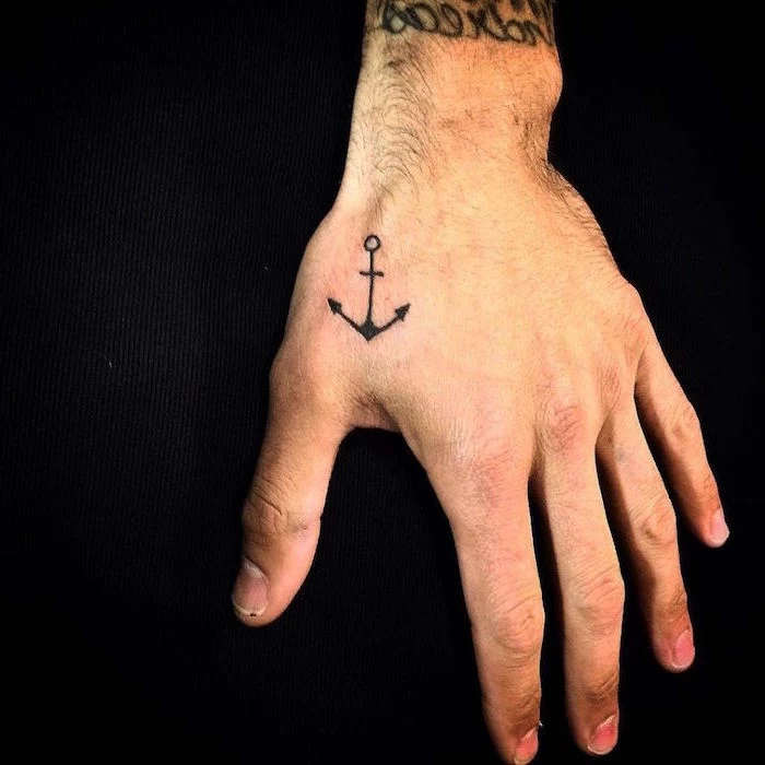 hand tattoo forearm tattoos for men small anchor on hand placed on black fabric