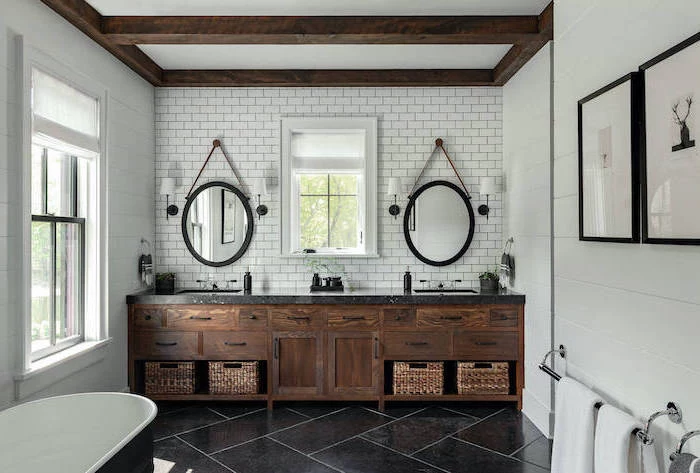 large wooden vanity with two sinks two mirrors mounted on wall covered with subway tiles farmhouse bathroom ideas black tiles on the floor