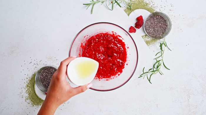 mashed raspberries in glass bowl easy vegan appetizers lemon juice added two bowls of chia seeds on the side