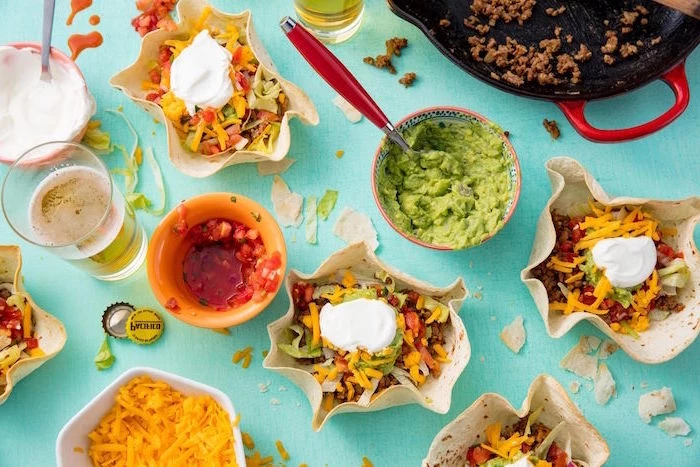 mexican dishes blue surface covered with different types of ingredients for tacos guacamole salsa glass of beer