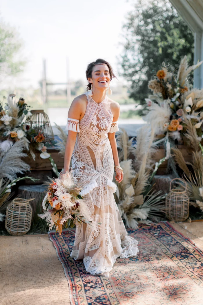 plus size beach wedding dresses brunette woman wearing a dress made of lace holding a bouquet with flowers and pampas grass