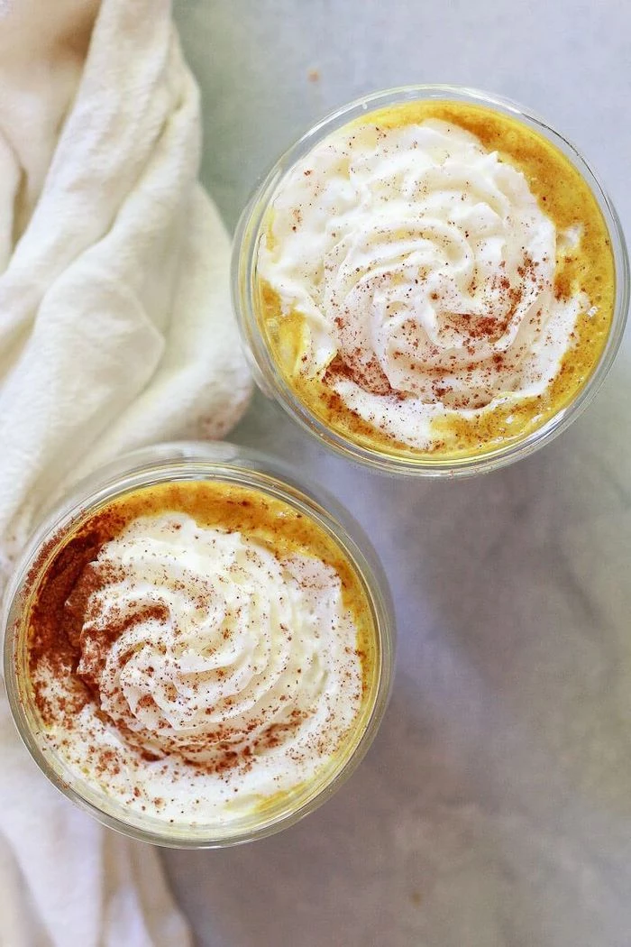 pumpkin spice latte garnished with turmeric cinnamon whipped cream in two glasses best detox cleanse for weight loss